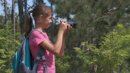 Young Girl Taking Pictures in a Green Forest