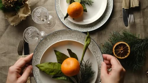 Festive Holiday Table Setting with Orange and Sprigs