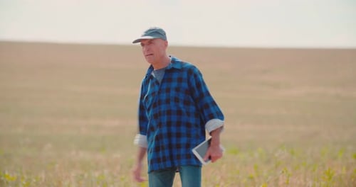 Farmer Using Digital Tablet While Examining Field