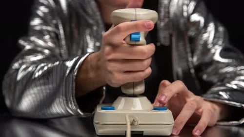 Person playing old vintage arcade game with joystick
