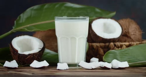 Coconut Milk in a Glass and Fresh Coconuts in the Basket Rotate Slowly.