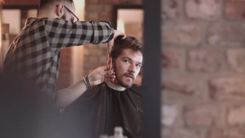 Hombre adulto joven cortado de pelo en la barbería