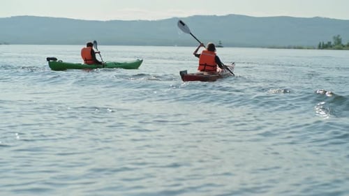 People Kayaking on a Lake in Bright Sunlight