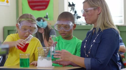 Teacher and students make science experiment in school classroom