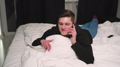 Handsome Caucasian Man Talking on Phone in Bedroom