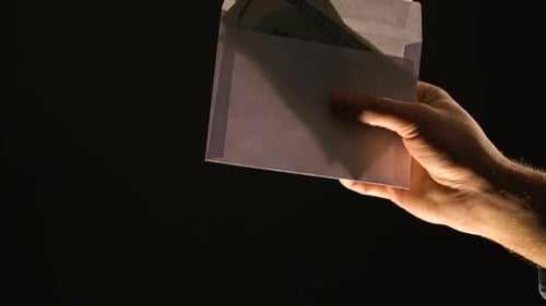 Hand Exchange of Cash in White Envelope