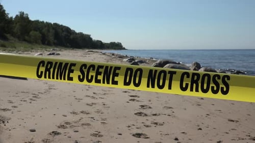 Crime Scene Tape on Sandy Ocean Beach