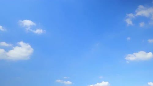 Bright Blue Sky with Drifting White Clouds