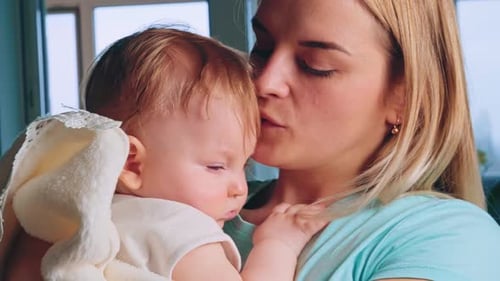Loving Mother Holds Sleeping Baby Indoors