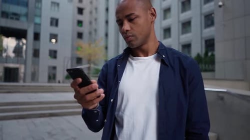Ethnic Man Using Smartphone on Street