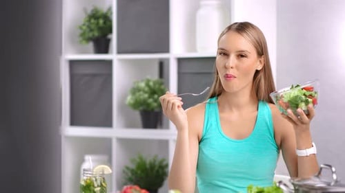 Woman Enjoys Healthy Salad in Bright Kitchen