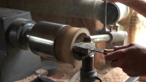 Woodworker Carving Wooden Object on Lathe
