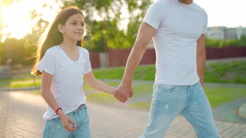 Dad and Daughter Walk Around Their Area at Sunset