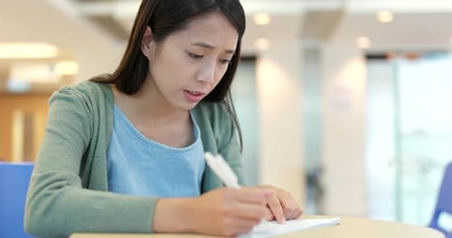 Young Woman Writing at Desk Indoors