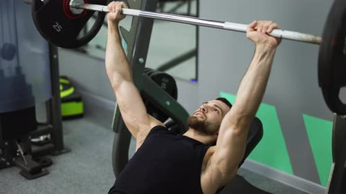 Men Laying and Working Out Barbell Bench Press in the Gym