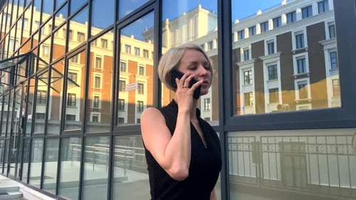 Woman Talking on Mobile Phone Outside Building