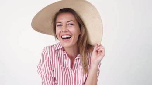 Cheerful Woman Catching and Wearing Summer Hat