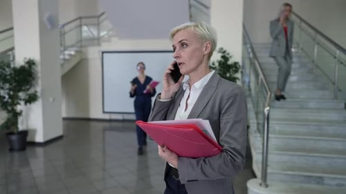 Businesswoman Talking on Phone in Modern Office Lobby