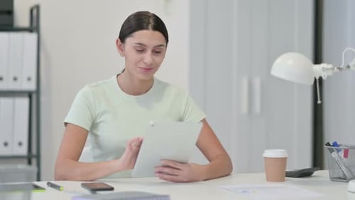 Young Woman Uses Tablet at Desk