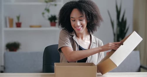 Close Up Curly Haired Young Brunette Receives Parcel From Courier From Internet Store, Accepts