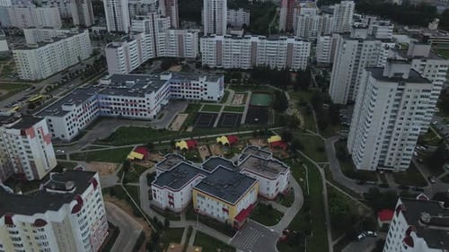 City block. Modern multi-storey buildings. Flying at dusk at sunset.