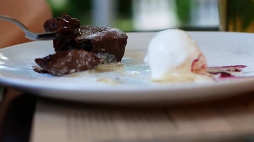 Women eating chocolate cake in a summer cafe. Liquid chocolate flows smoothly out of the cake