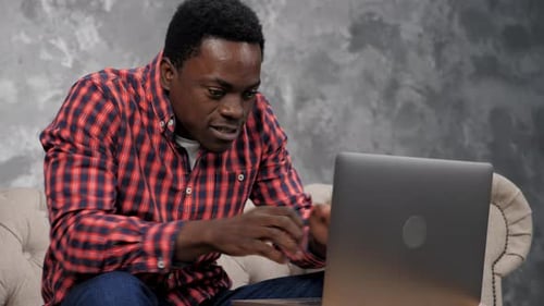 Excited African American Student Looks Laptop Celebrating Admission University