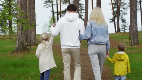 Family of Four Walking in Forest
