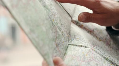 La mano de un hombre señala el mapa y busca el destino, de cerca