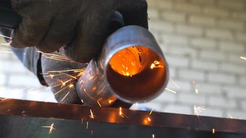 Nahaufnahme der Metallbearbeitung mit einer Kreissäge. Hände des Mechanikers Halten des Instruments und Schleifen