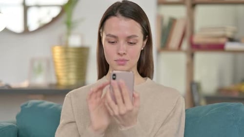 Woman Using Mobile Phone Sitting on Couch