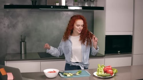 Woman Sings and Prepares Salad in Kitchen