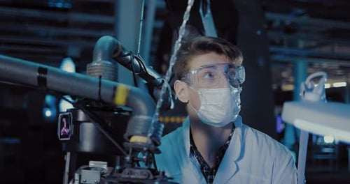 Young Adult Works With Machinery in Factory