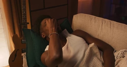 Handsome Man Sleeping on Bed Woken Up By Smartphone Alarm Clock Ring and Shocked