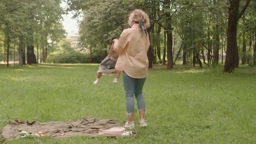 Woman Spins Baby Around in Green Park