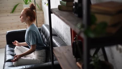 Woman Meditating on Couch at Home