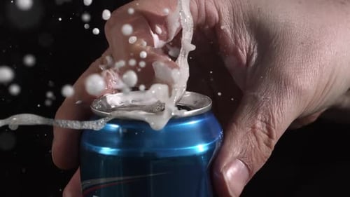 Zeitlupe beim Öffnen und Sprühen der Aluminiumdose, während die Lasche gezogen wird.