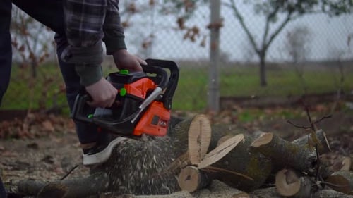 Holzfäller schneidet Baum- und Holzspäne, die in Zeitlupe herumfliegen