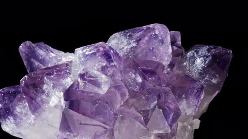 Nahtlos rotierendes lila Mineral (Amethyst) vor schwarzem Hintergrund.