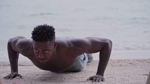 African American Man Doing Pushups While Exercising at the Beach