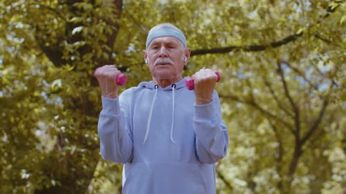 Senior Man Exercising Making Dumbbell Weight Lifting Exercises Practicing Sports Training in Park