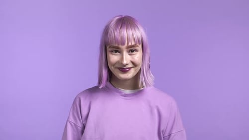 Portrait of Hipster Woman with Dyed Violet Hair on Purple Studio Background