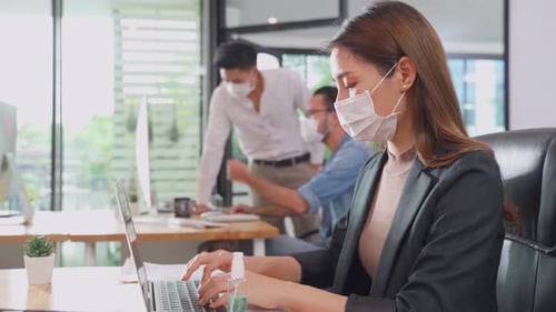 Group of Asian team business people working in office with new normal social distancing lifestyle.