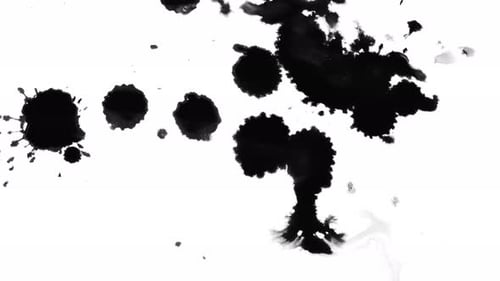 Black Ink Spreads and Drops on White Surface