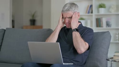 Mature Man Frustrated Using Laptop at Home