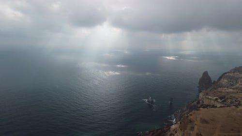 Luftbild von oben auf ruhiges azurblaues Meer und vulkanische Felsküsten