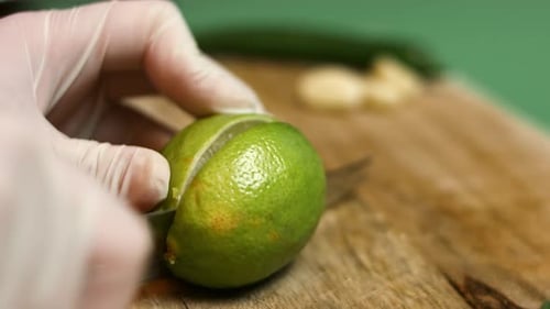 Die Arme des Barkeepers fügen frischen Saft in transparentes Glas mit grüner Minze und Limettenscheiben hinzu