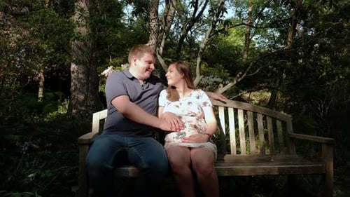 Heureuse femme enceinte et son mari dans la forêt