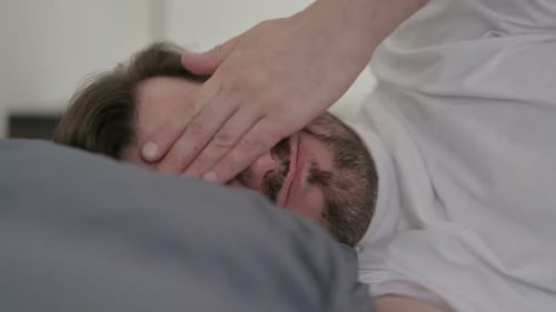 Portrait of Young Man Having Headache While Sleeping in Bed