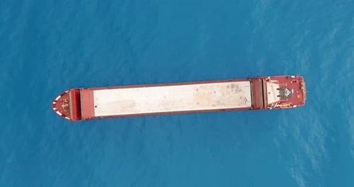 Aerial View. Red Deck Cargo Ship Sailing on Open Sea.